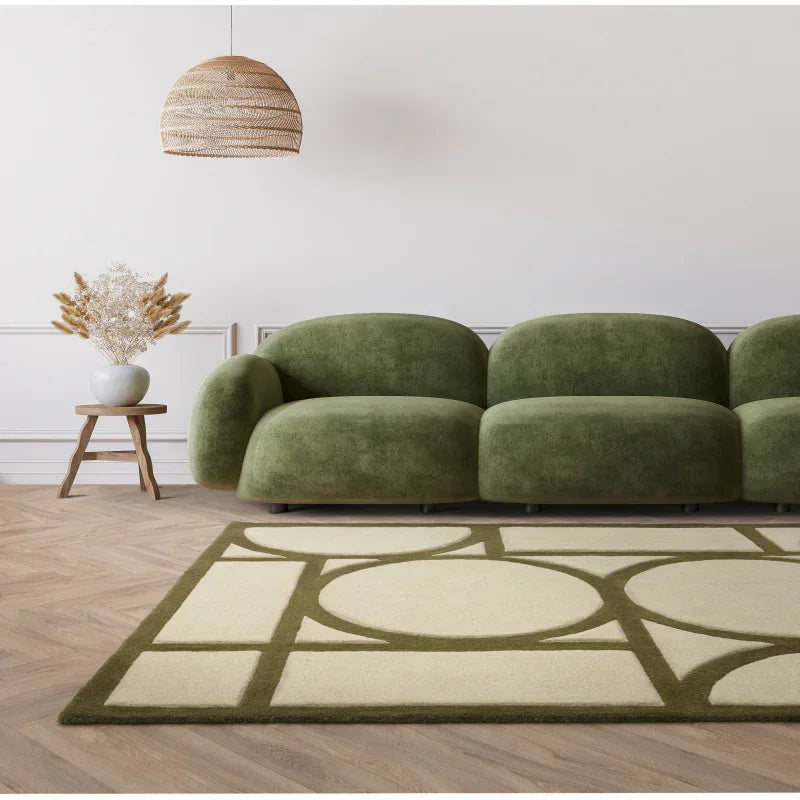 Green velvet sofa with modern curved design and geometric rug in living room