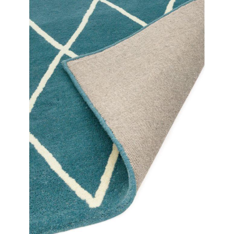 Blue geometric rug with white lines, corner flipped to show backing detail