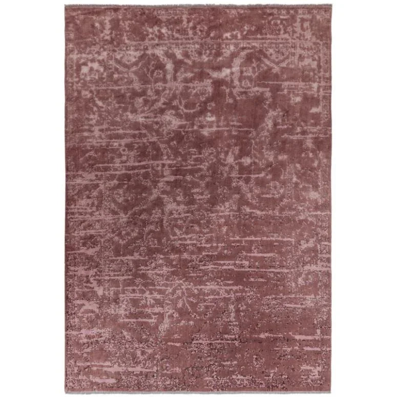 Blush pink area rug with subtle distressed pattern and soft textured finish