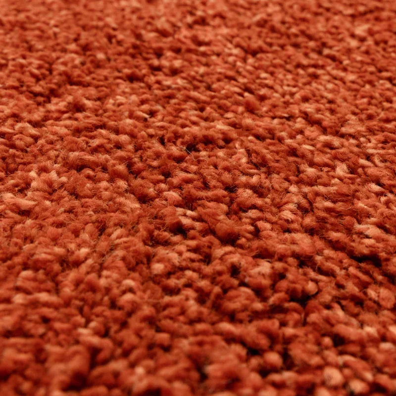 Close up of textured orange carpet pile with soft woven fibers
