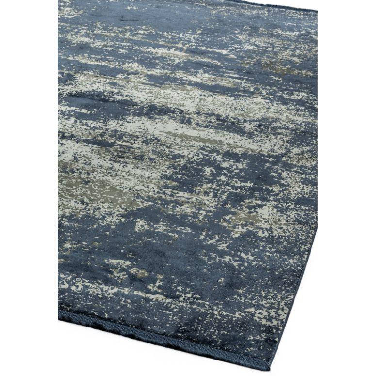 Modern area rug with abstract blue and beige pattern, corner angle view