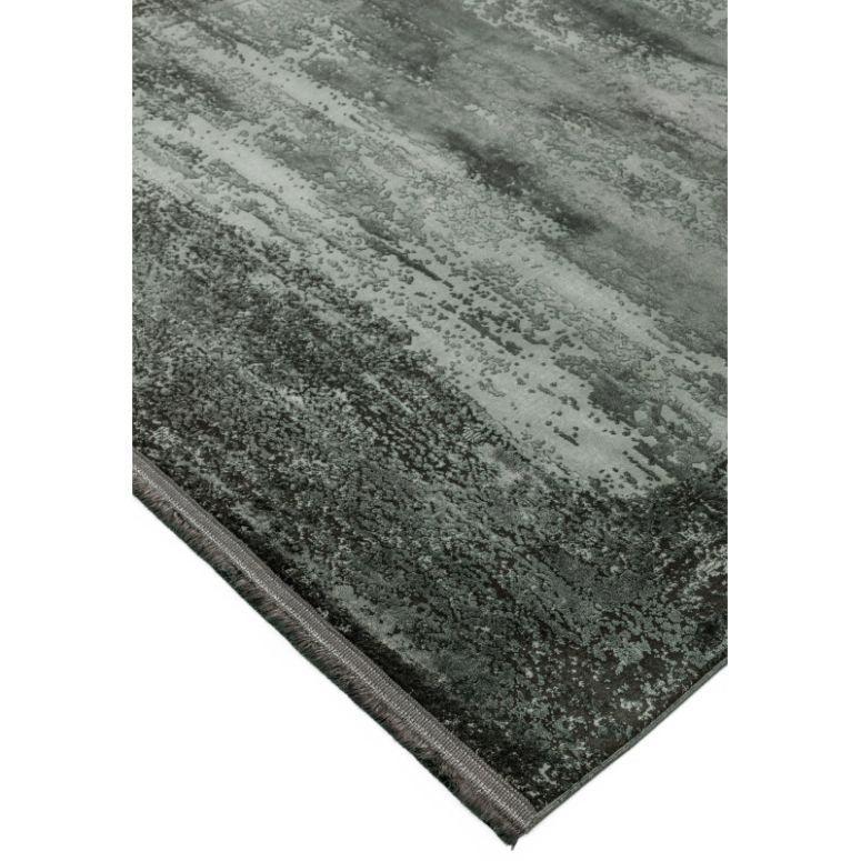 Grey abstract area rug with textured pattern and stitched edge, corner view