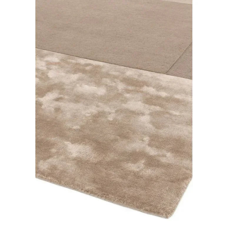 Beige area rug with plush texture and subtle two-tone pattern on corner angle view