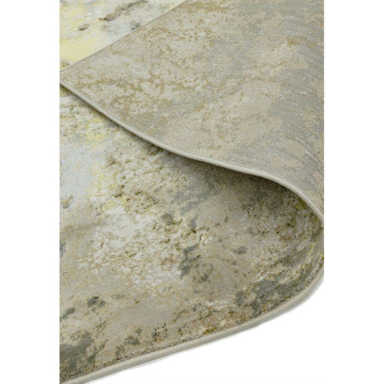 Beige abstract area rug with folded corner showing soft textured pile and subtle color pattern