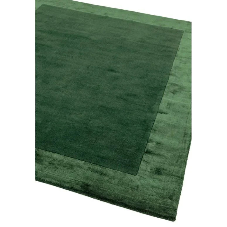 Green bordered area rug with plush texture shown from corner angle