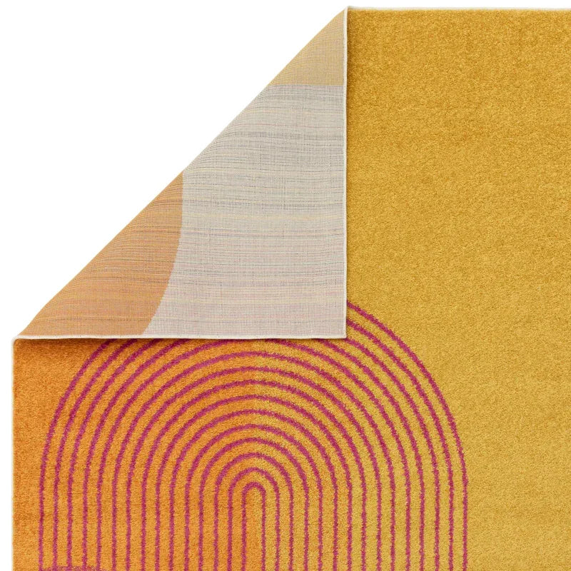 Yellow and orange area rug with pink arch pattern, corner flipped to show backing