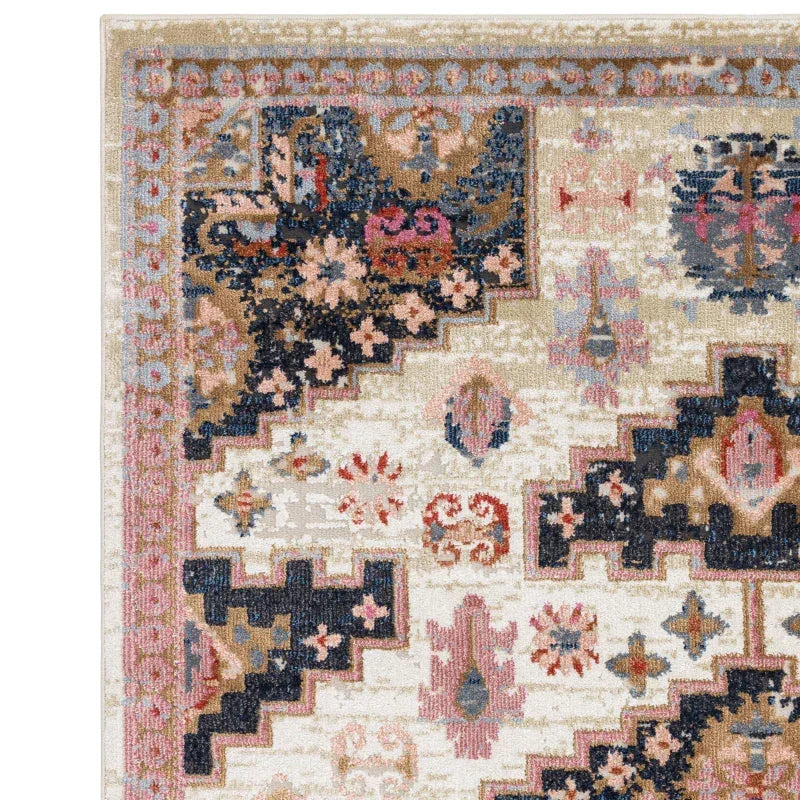 Traditional patterned area rug with beige, navy, and pink geometric and floral details