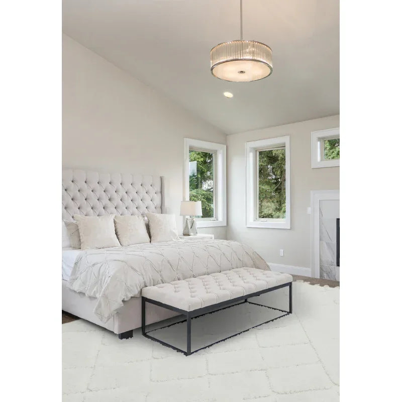 Modern bedroom with upholstered bed, quilted bench, and neutral decor