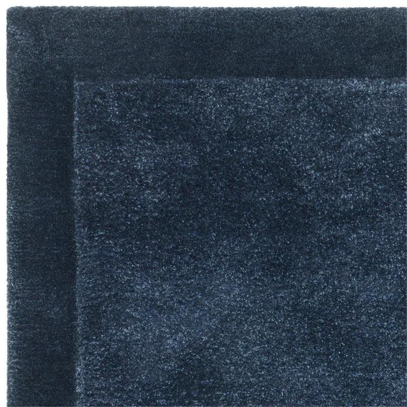 Dark blue shaggy rug corner showing soft pile texture and subtle border design