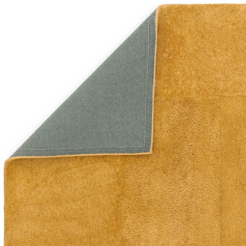 Mustard yellow area rug corner folded to show backing and texture
