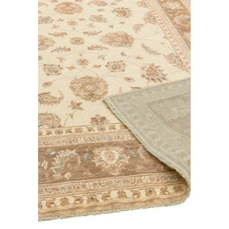 Traditional beige floral area rug with brown border and corner fold showing backing