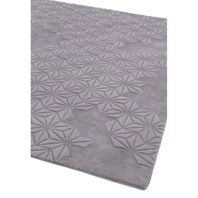 Grey patterned area rug with geometric raised texture viewed from angle