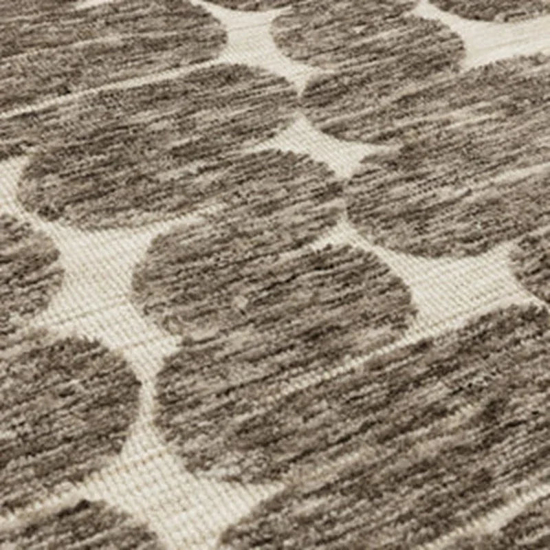 Beige and brown patterned rug with textured circular design, close-up angle