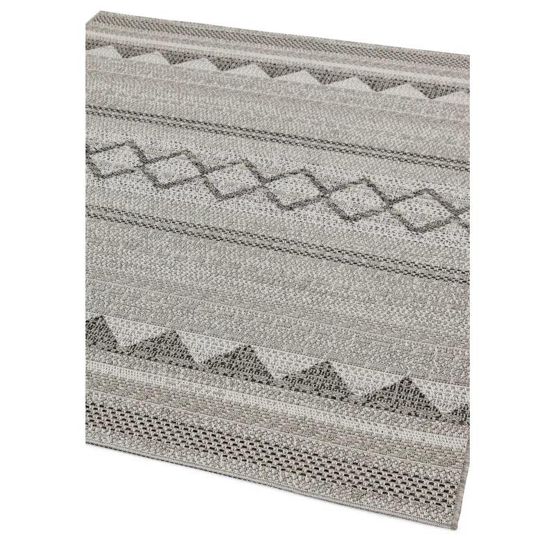 Grey patterned area rug with geometric design and textured fabric close up