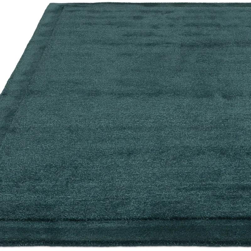 Teal rectangular area rug with a soft texture and simple border design
