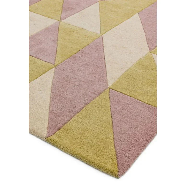 Geometric area rug with yellow, pink, and cream triangles, close corner view