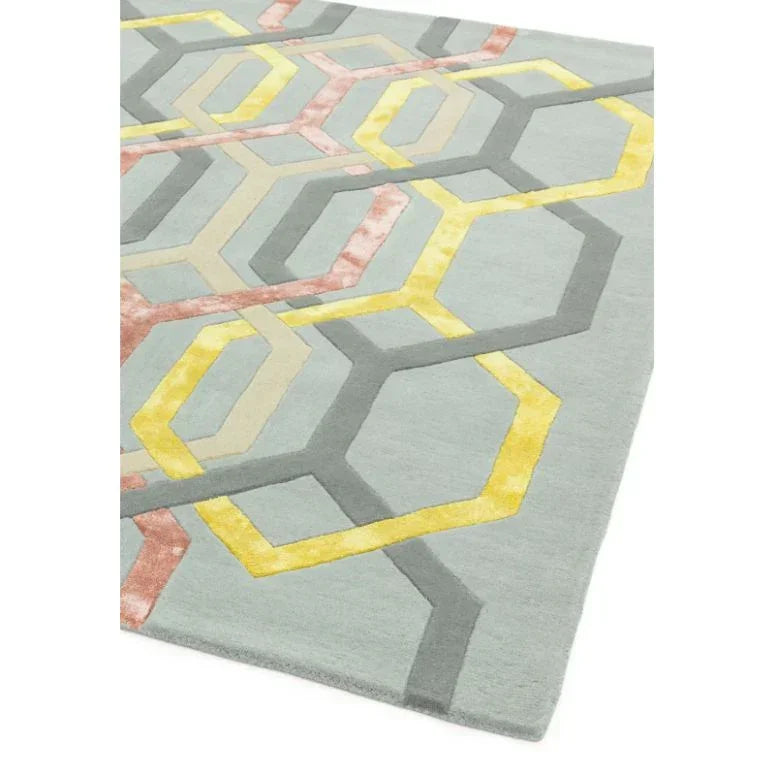 Modern geometric area rug with yellow, grey and pink hexagon pattern on light grey background