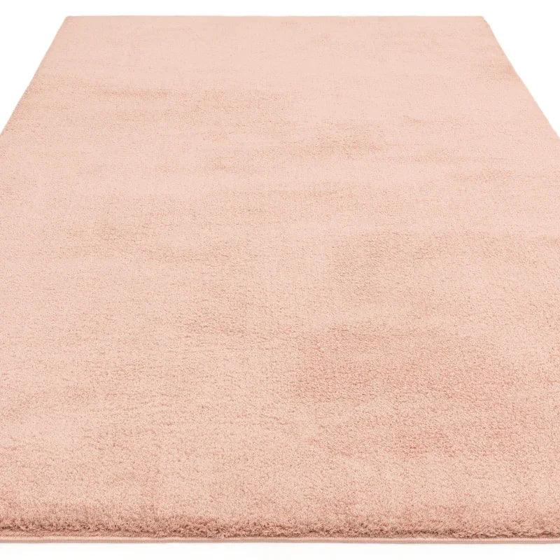 Blush pink area rug with soft pile and rectangular shape