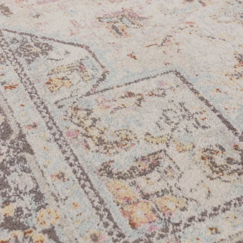 Close up of patterned area rug with light blue, beige and soft pastel details