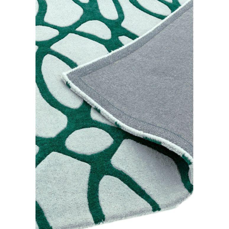 Green and white abstract pattern rug with corner flipped to show backing