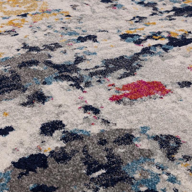 Abstract pattern area rug in grey, navy, yellow and pink with textured pile close-up