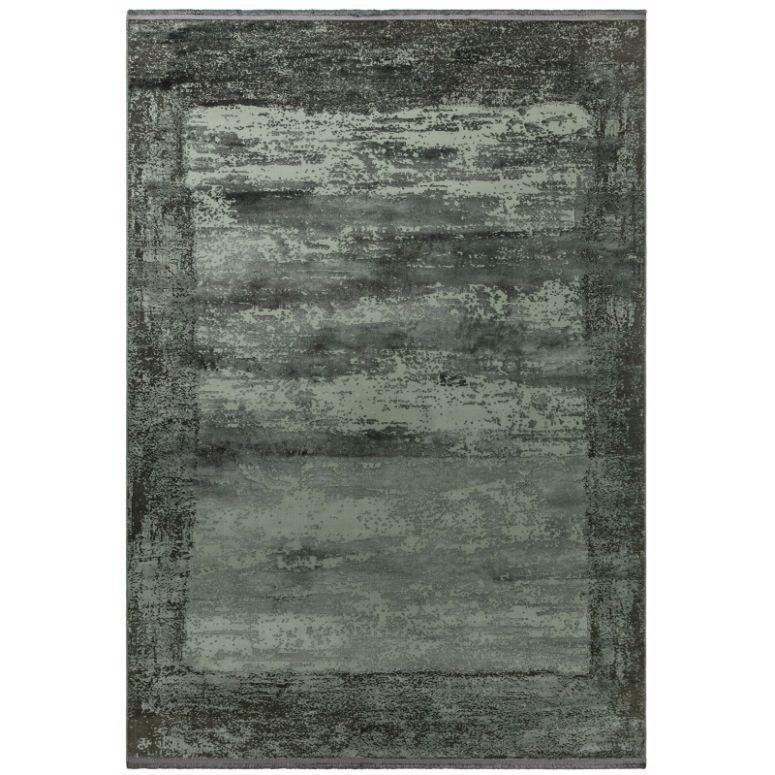 Green area rug with distressed border and textured effect