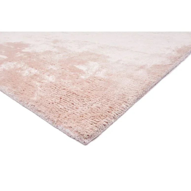 Blush pink plush area rug with soft textured pile, shown from a corner angle