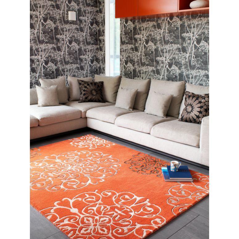 Orange patterned area rug with white floral design in modern living room with corner sofa