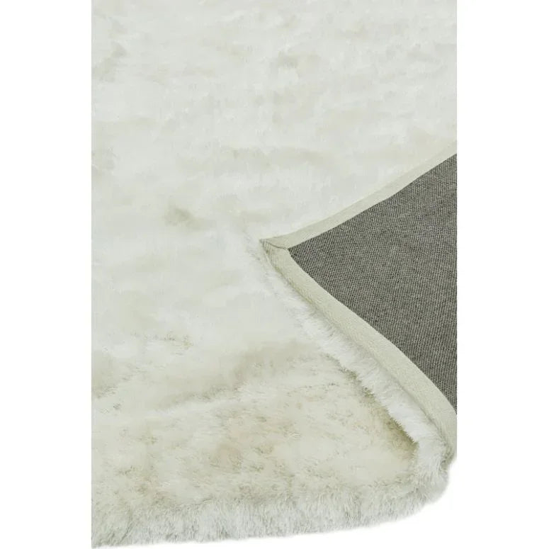 White faux fur rug with corner flipped to show non-slip backing