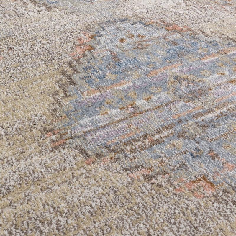 Close up of patterned area rug with blue, beige, and taupe textured design