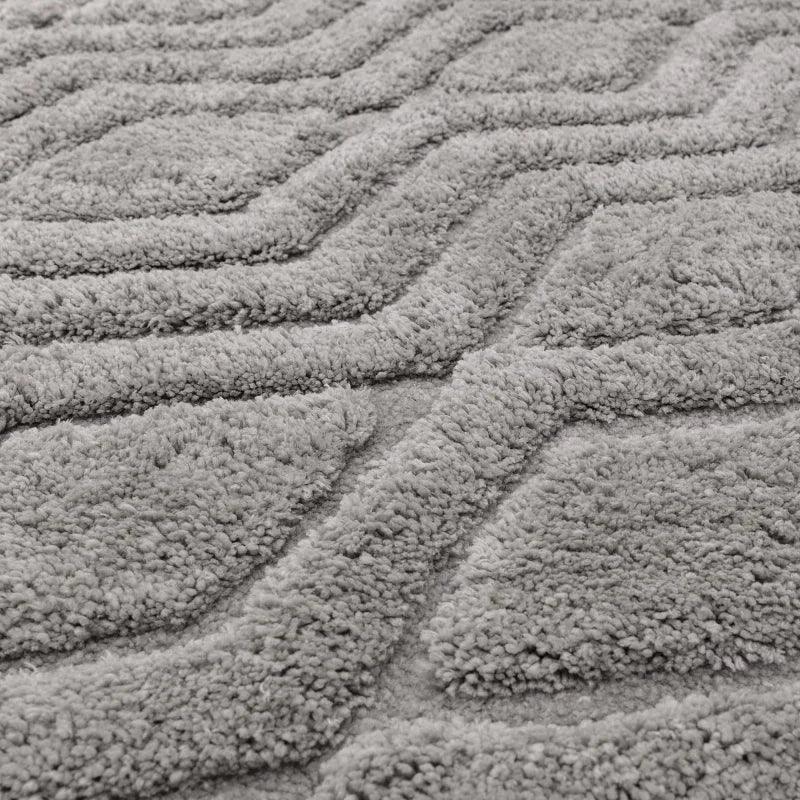 Grey textured rug with raised geometric chevron pattern and soft pile close-up