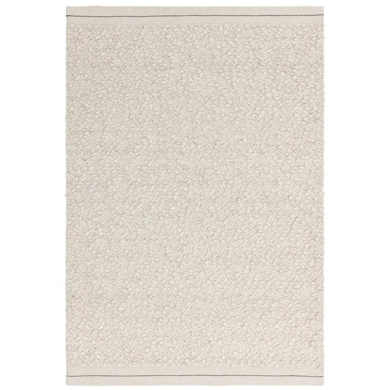Ivory textured area rug with subtle border, photographed from above on a white background