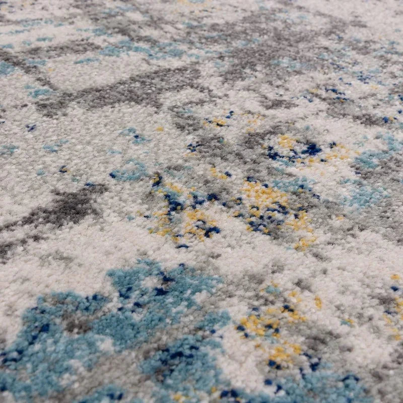 close up of multicoloured area rug with abstract blue, yellow and grey pattern
