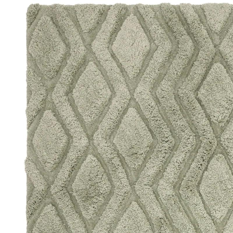 Grey shaggy rug with diamond pattern and textured pile, close-up view of corner
