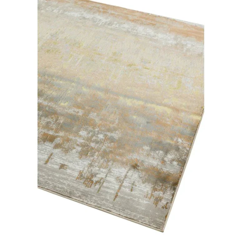 Abstract patterned area rug with beige, grey, and gold tones, shown from angled view