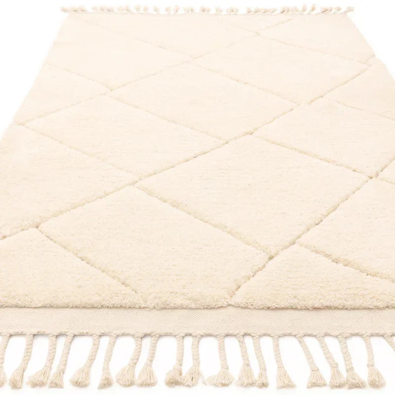 Cream diamond pattern rug with tasselled edge, angled view
