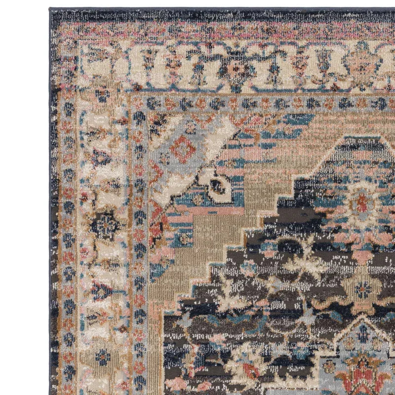 Corner of patterned area rug displaying muted blue, beige, and terracotta colors with border detail
