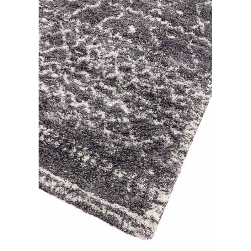 Grey and white patterned shaggy rug corner with textured pile