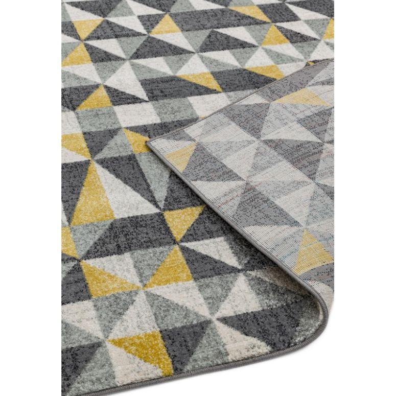 Geometric pattern area rug in grey, yellow, and white with corner slightly turned up