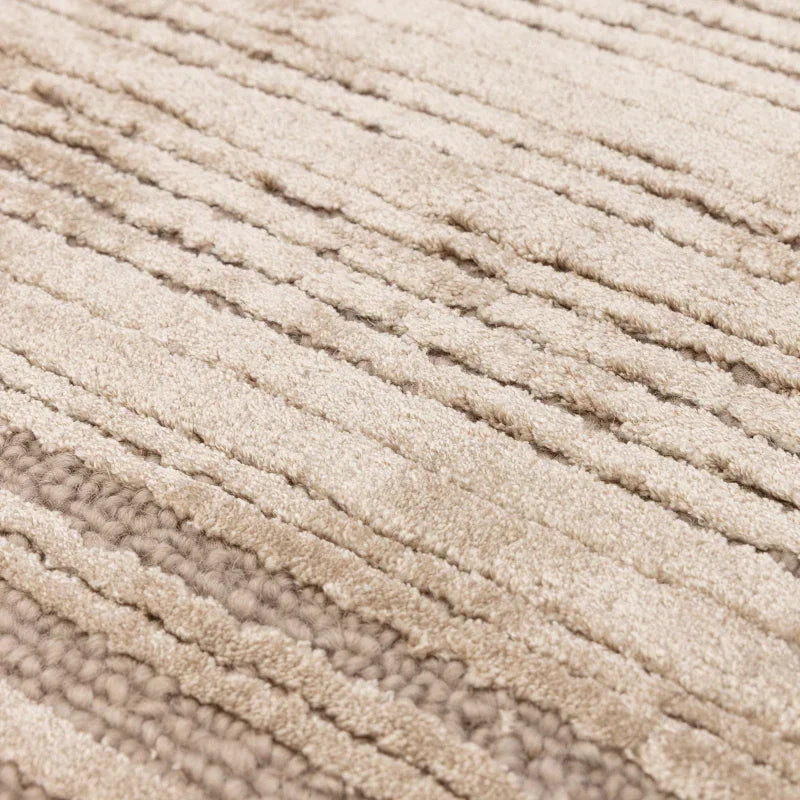 Beige textured rug with raised striped pattern and soft woven material closeup