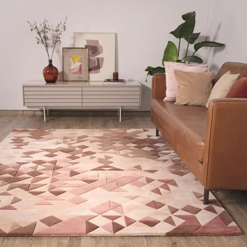 Geometric patterned area rug in neutral tones with tan sofa and modern sideboard in living room