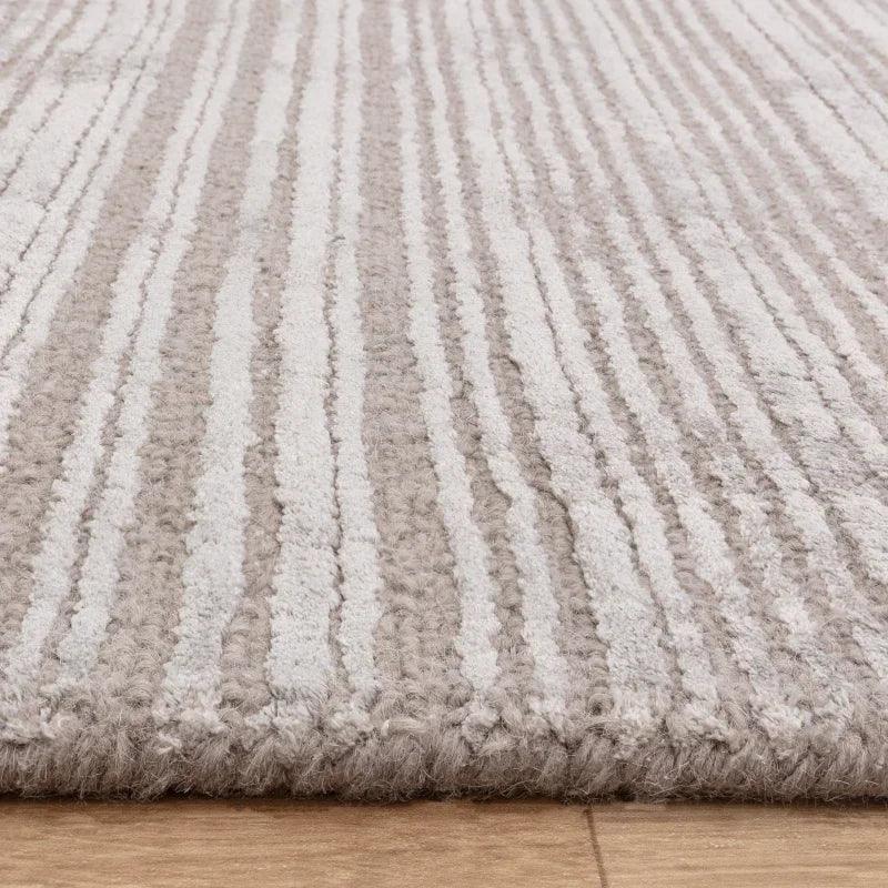 Close view of beige and cream striped rug on wooden floor