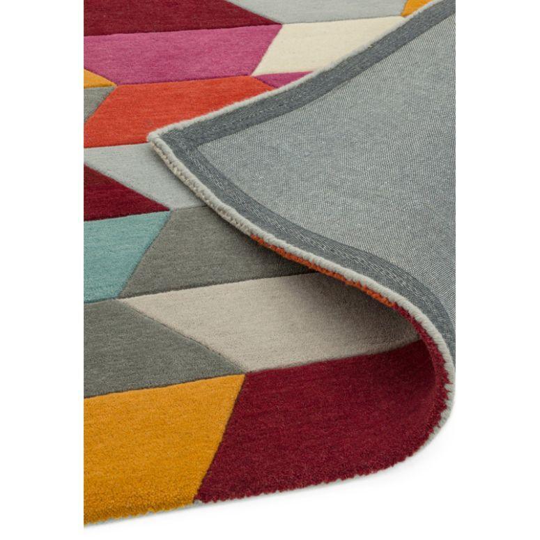 Geometric multicolour rug with folded corner showing textured weave and vibrant pattern