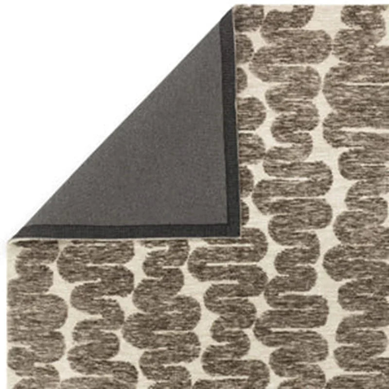 Beige and brown patterned area rug corner with visible underside