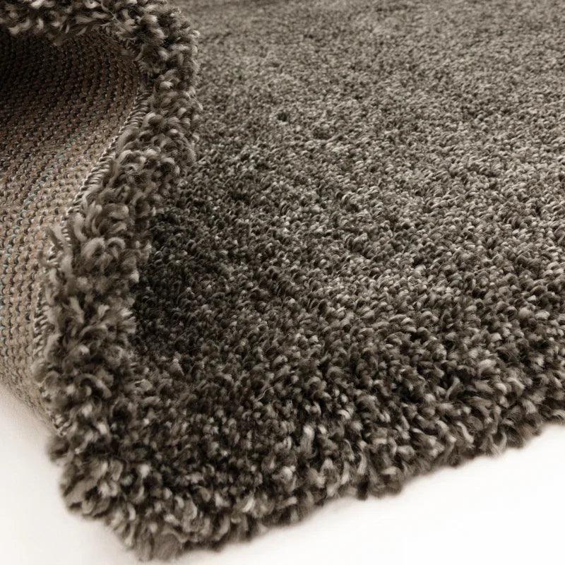 Close view of grey shaggy rug texture and woven backing for living room or bedroom