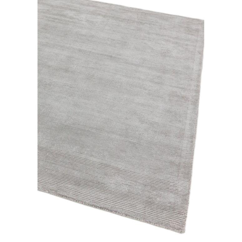 Light grey area rug with subtle textured design shown from an angled top view