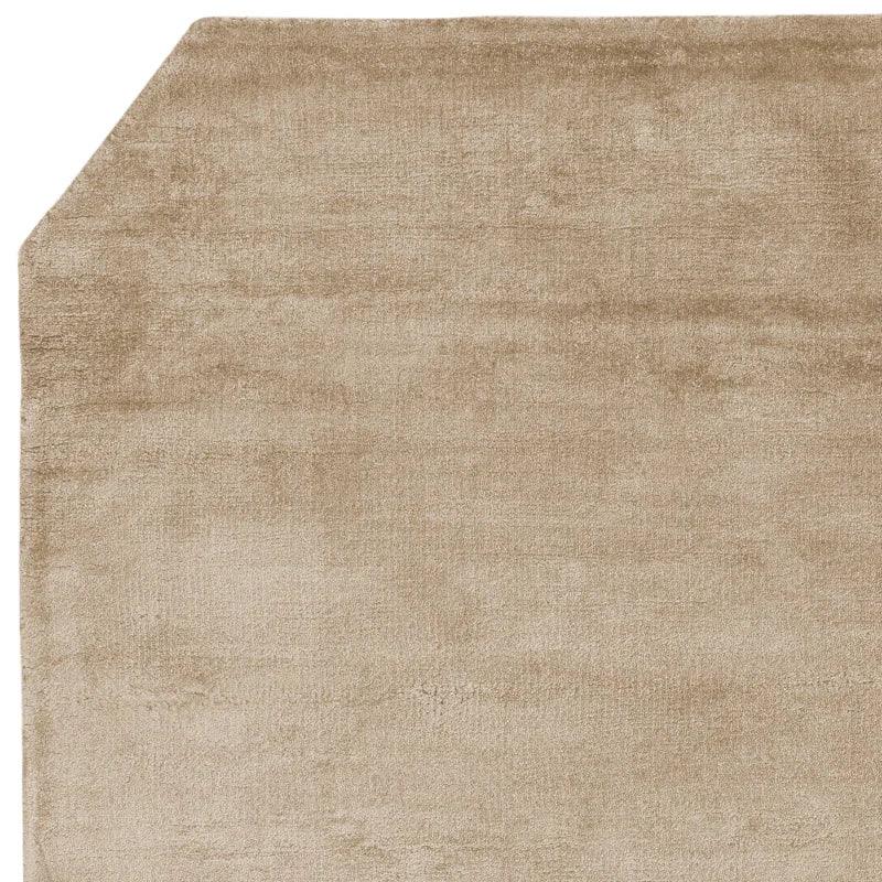 Beige rectangular rug with cut corner and soft textured surface