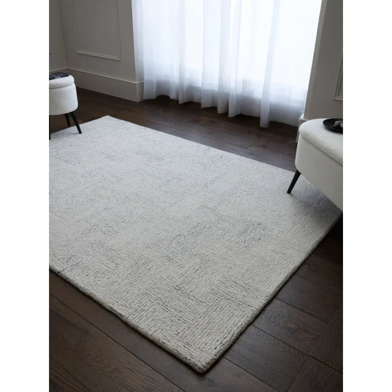 Light grey patterned rug on dark wood floor in modern living room