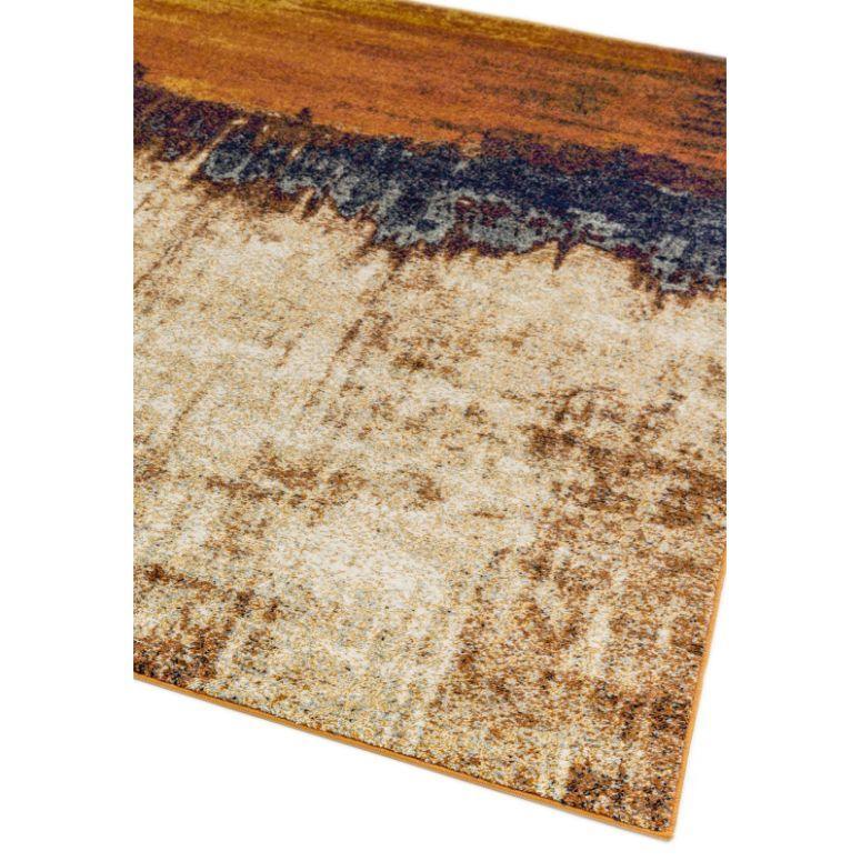 Modern area rug with gradient brown, beige and dark blue pattern, close-up corner view