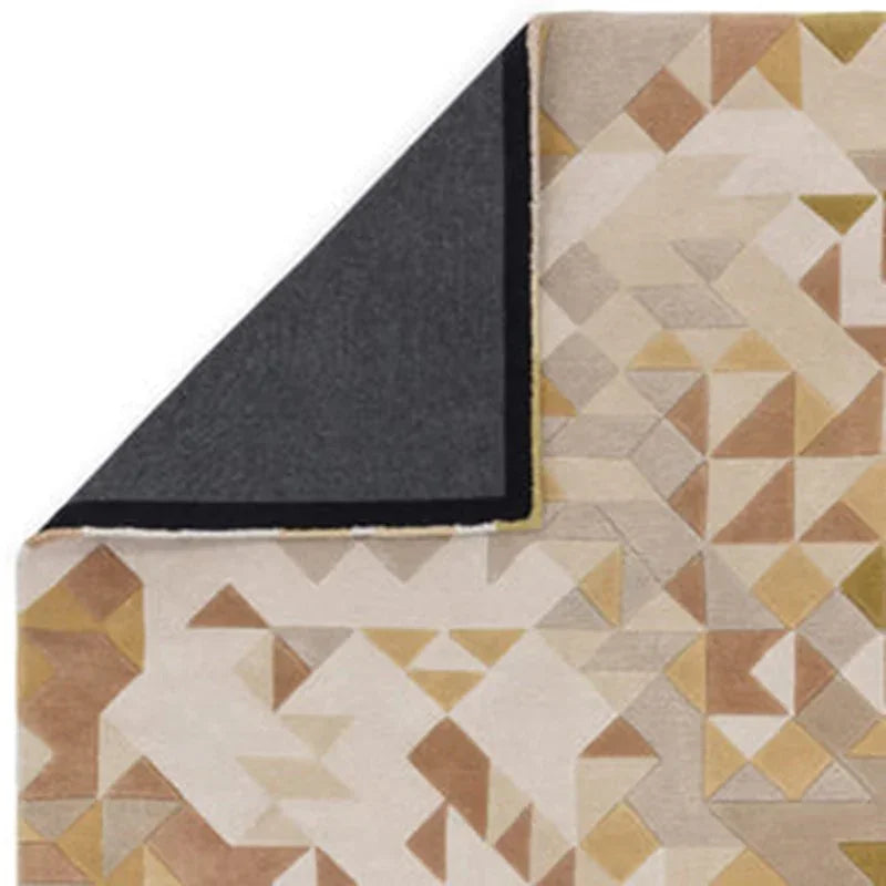 Beige geometric patterned rug with corner flipped to show dark non-slip backing